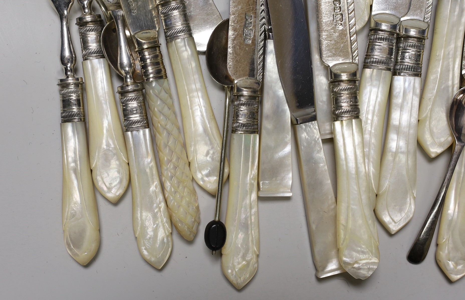 A selection of mounted mother-of-pearl knives and forks, together with finely decorated enamelled spoons